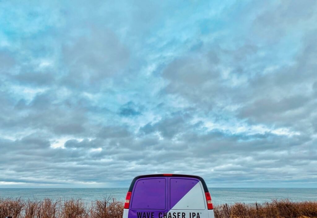 Montauk Brewing Company's Wave Chaser IPA van parked in front of a cloudy sea view