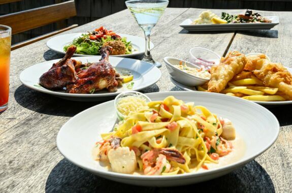 'Five different dinner plates, including pasta, chicken, and fish and chips at Inlet Seafood Restaurant and Dock