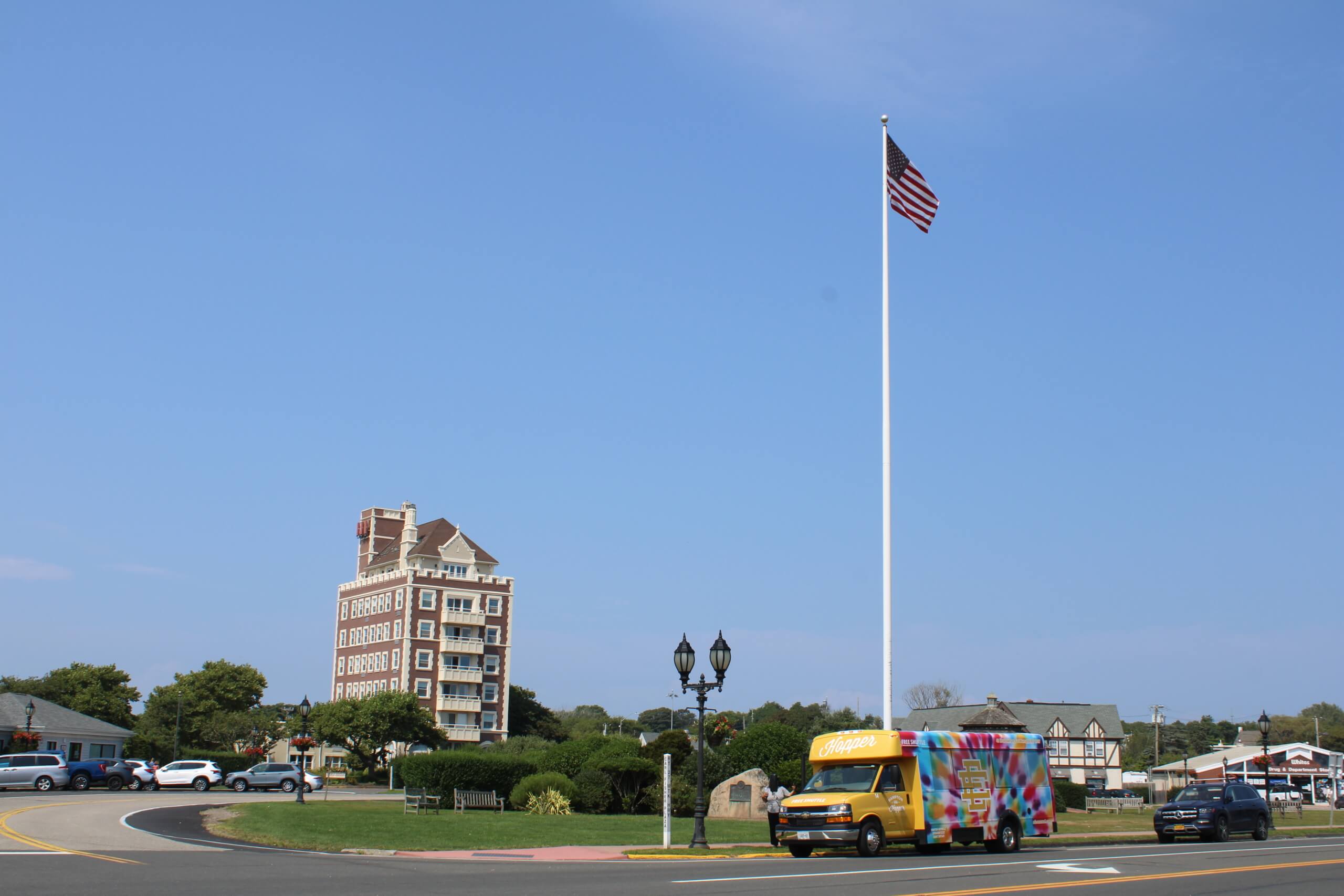 Montauk's circle, Carl Fisher Plaza, with the American Flag and the Hampton Hopper bus, August 2024
