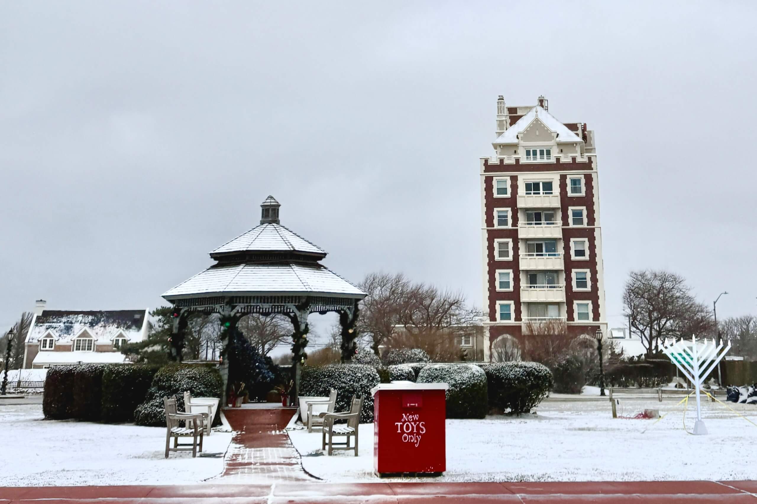Montauk's gazebo, Toys for Tots bin, Menorah for Hanukkah, and Carl Fisher Building covered in a light dusting of snow, December 2024