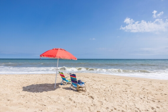'Image of 2 beach chairs and a beach umbrella on the beach, facing the ocean in Montauk