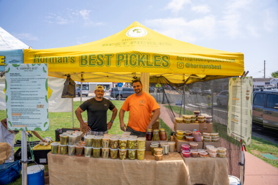 Horman's Pickles employees pose with products from their Montauk farmers market booth