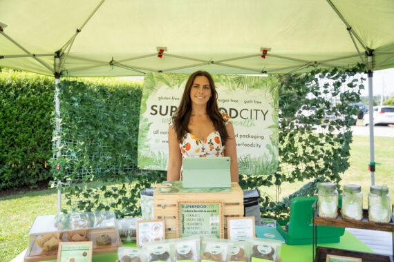 Caitlin Glover, CEO of Superfood City LLC stands with her products at her Montauk Farmers Market booth