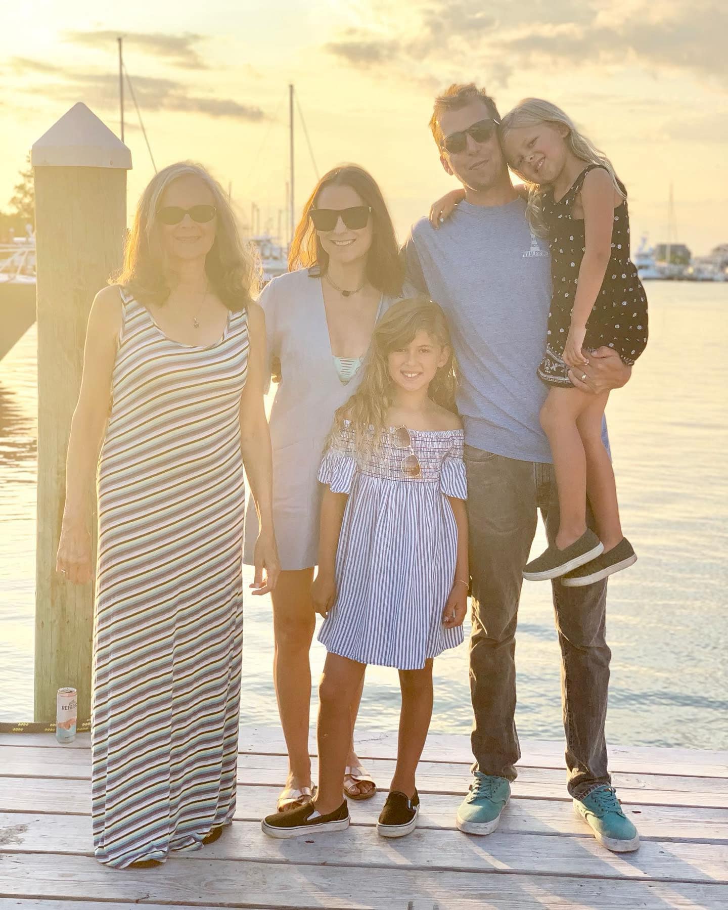 Family standing on dock in sunset
